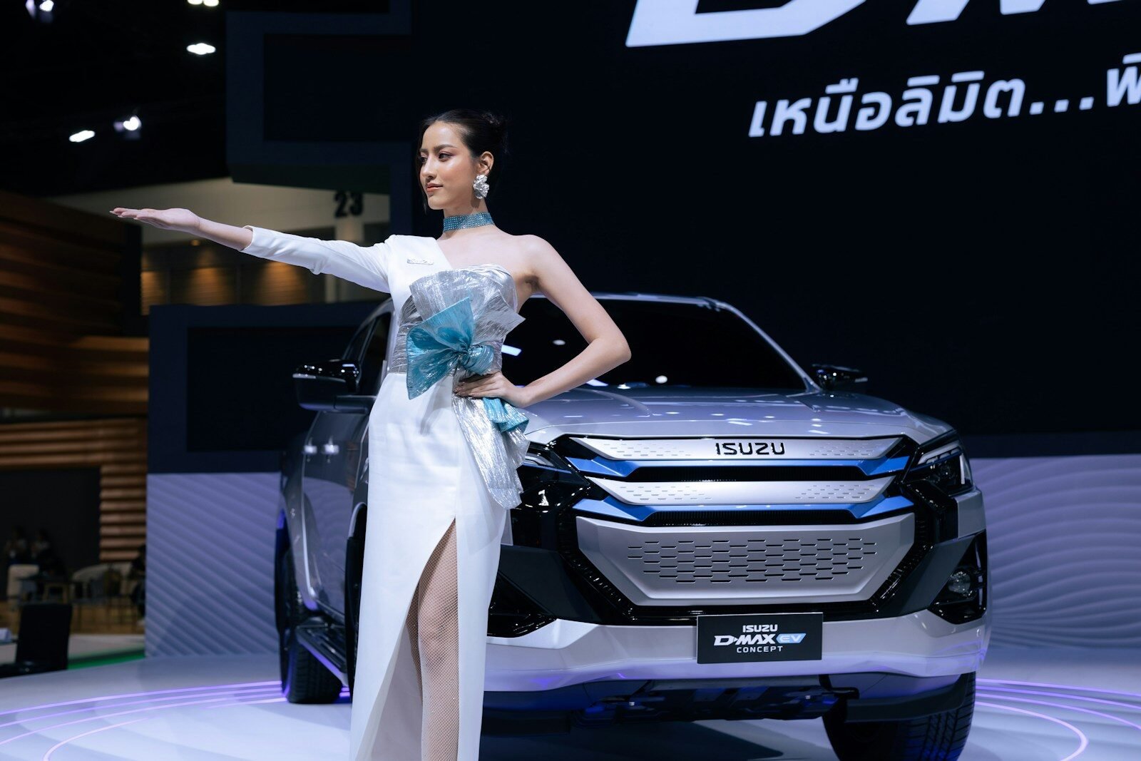 A woman standing next to a car on display